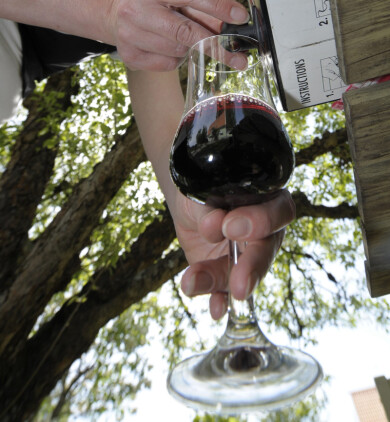 Nej, det behöver inte vara sommarens synder som ligger bakom gikten. Kvinna häller upp vin i ett glas.