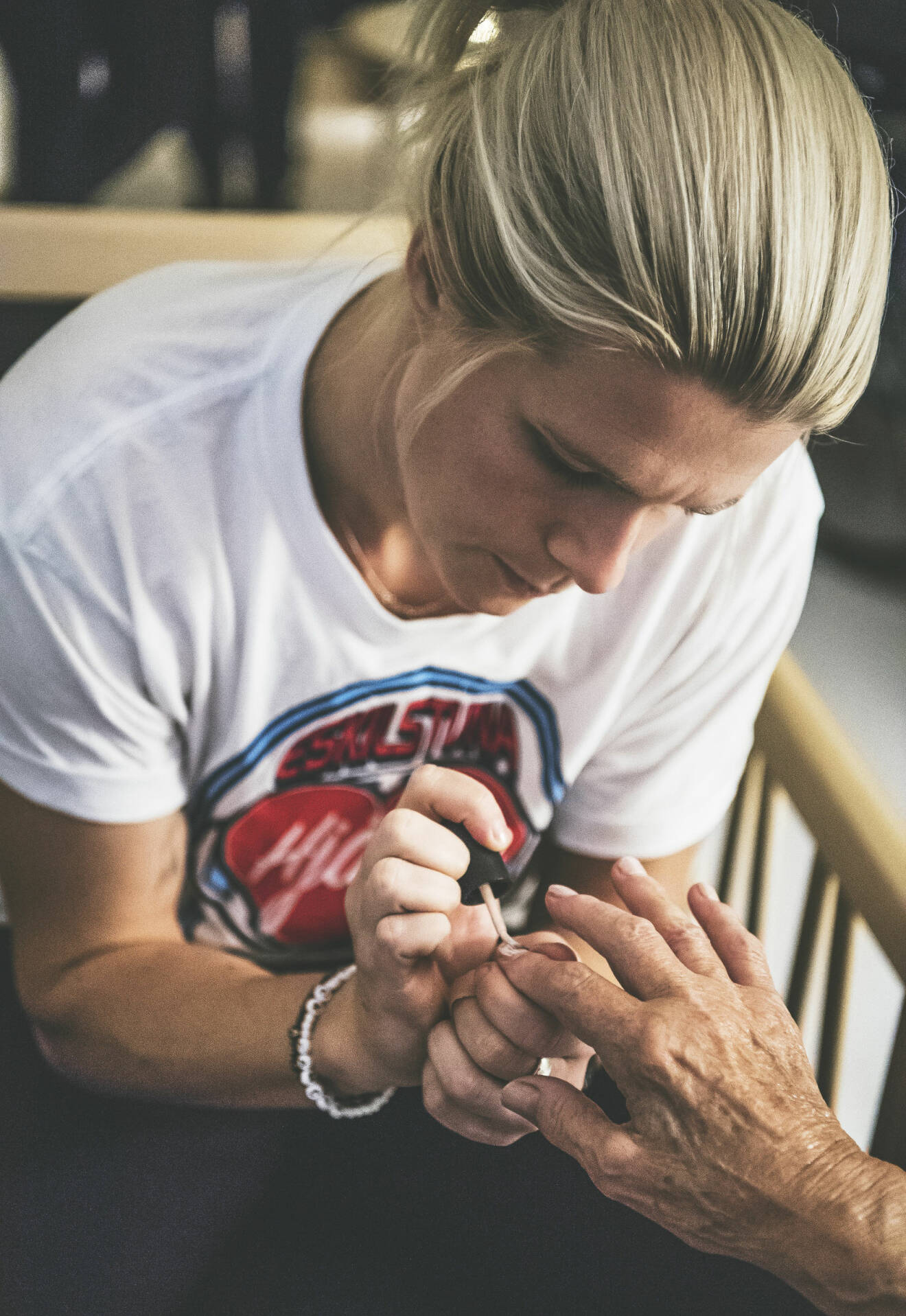 Målvakten Emilie Lundberg målar naglarna på Asta Jansson, 83 år.
