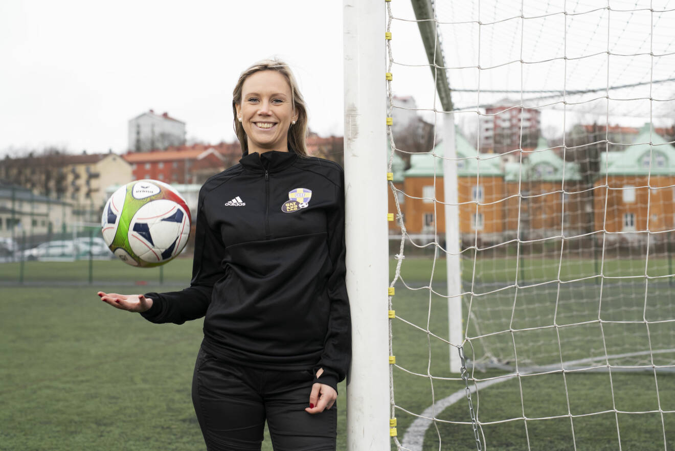 Sofie Nehvonen håller en fotboll i handen och ler mot kameran.