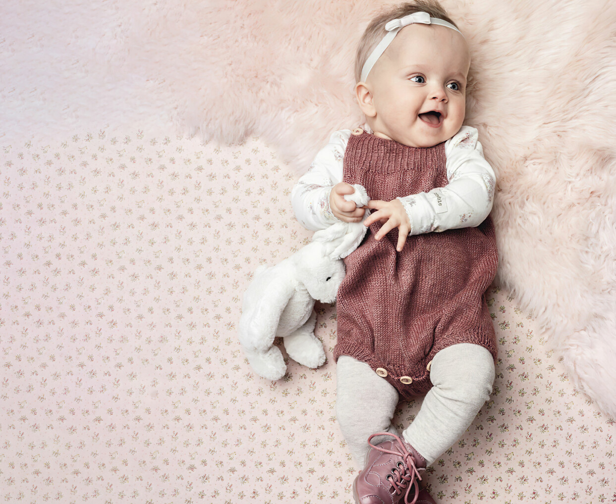 Den lilla sparkdräkten med dekorativa knappar är lika söt som praktisk. Liten bebis iklädd hemstickade sparkbyxor.