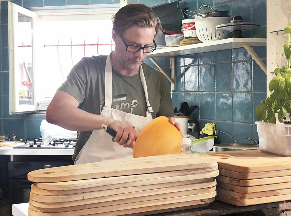 Mikael har alltid tyckt om att laga mat och nu driver han restaurang i Frankrike. Mikael lagar mat i restaurangen och framför honom ligger flera ljusa skärbrädor.