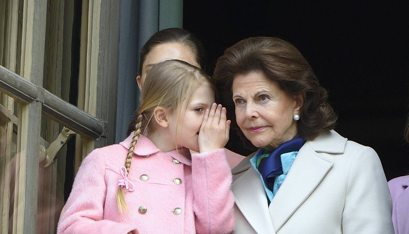 Estelle viskat försynt något till mormor Silvia på kungliga balkongen.