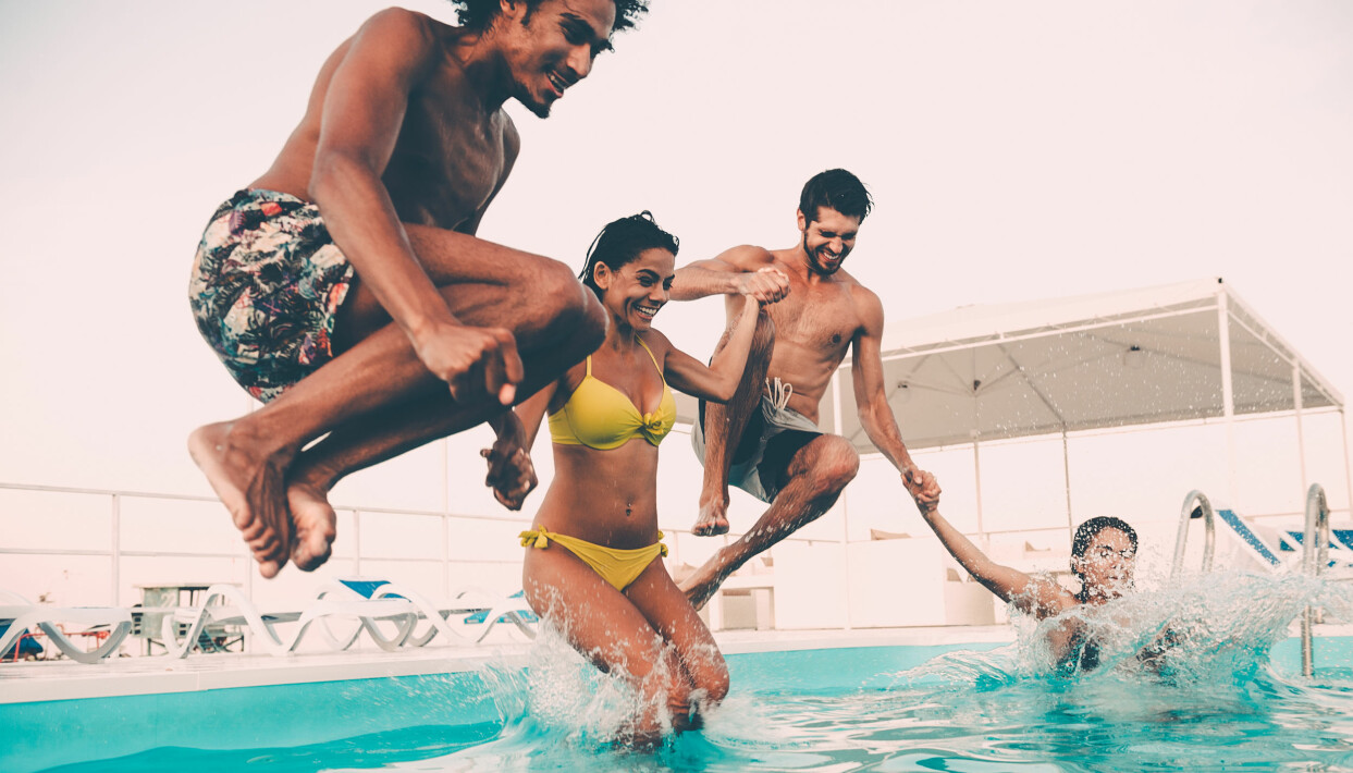 Om du har fått vatten i hörselgången rinner det oftast ut av sig själv, men det finns också olika knep att ta till. Foto: TT/Shutterstock Kompisgäng badar i en pool.