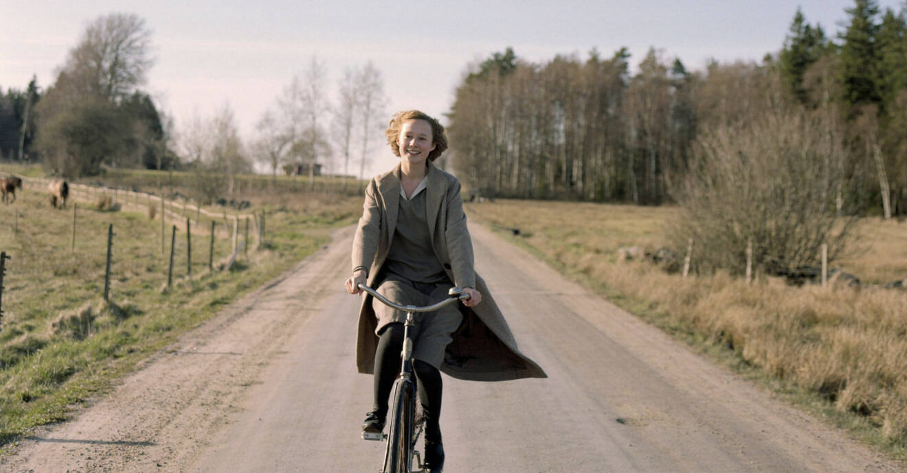Alba spelar Astrid Lindgren, här glad på cykel.
