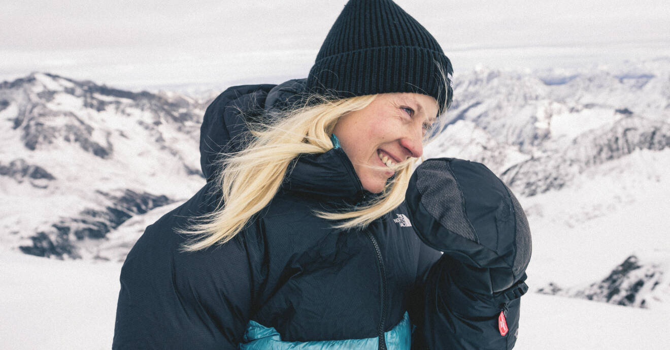 Emma ser lycklig ut på toppen av ett vintrigt berg.