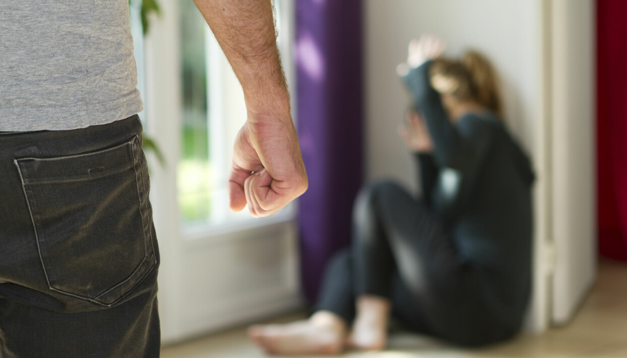 Om vi tar bort kön från språket när vi pratar om våld i nära relationer finns risken att skulden läggs på kvinnorna. Foto: Shutterstock En man ar hotande med sin knytnave nar en kvinna sitter i ett horn i hemmet.