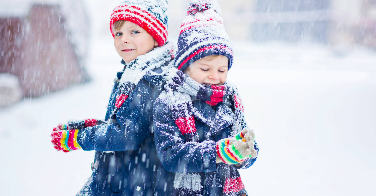 Två barn leker utomhus i snön.