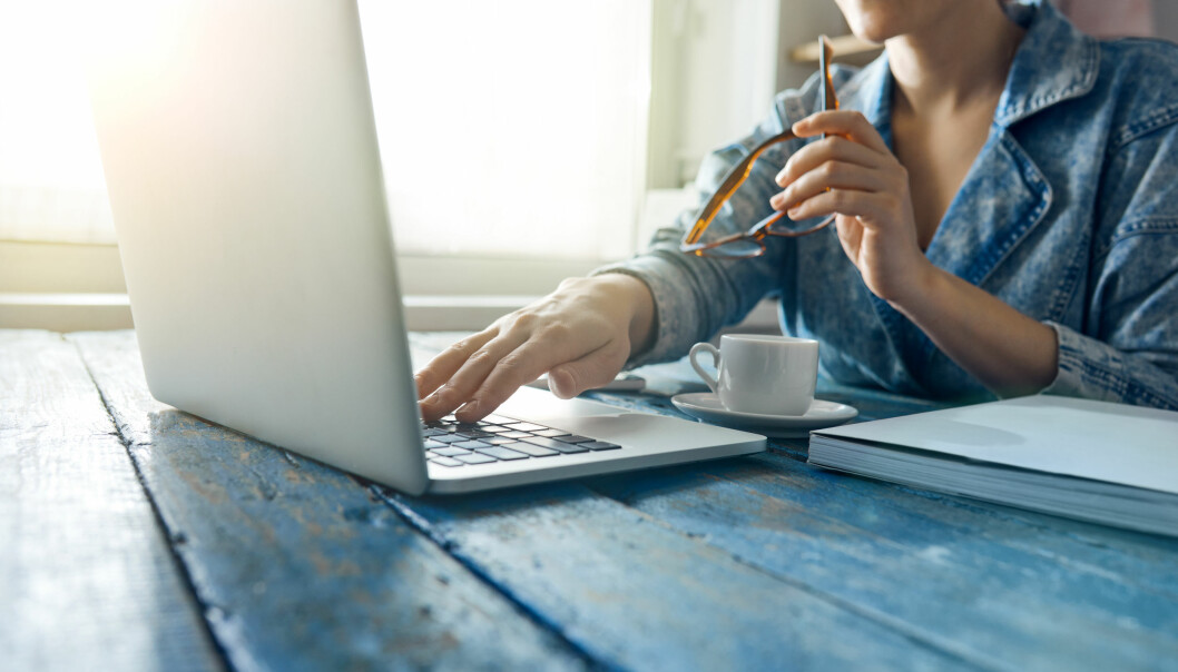 Jobba gärna nära ett fönster, om du har den möjligheten. Foto: Shutterstock/TT Kvinna sitter och arbetar med sin dator och en kaffekopp vid ett fönster.