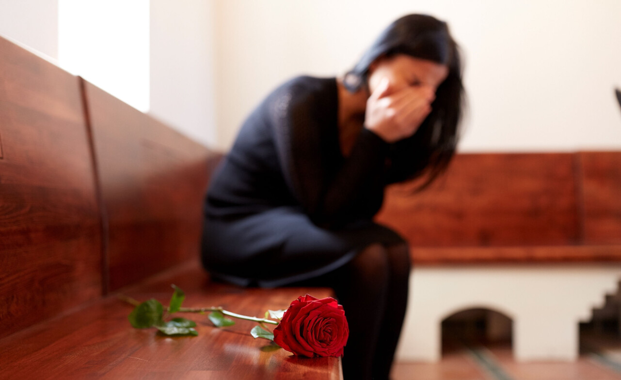 Kvinna gråter över sin mamma som precis dött.