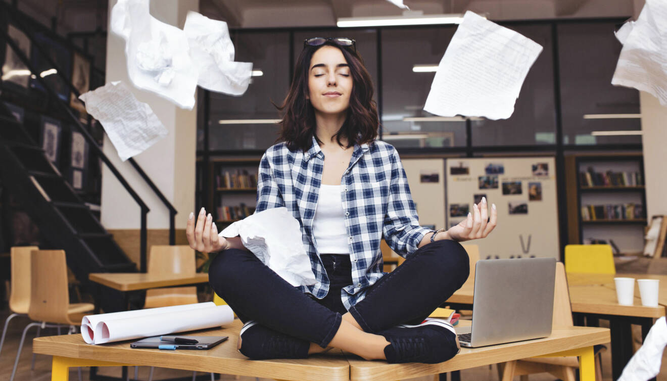 Stressad kvinna tar en paus vid skrivbord.