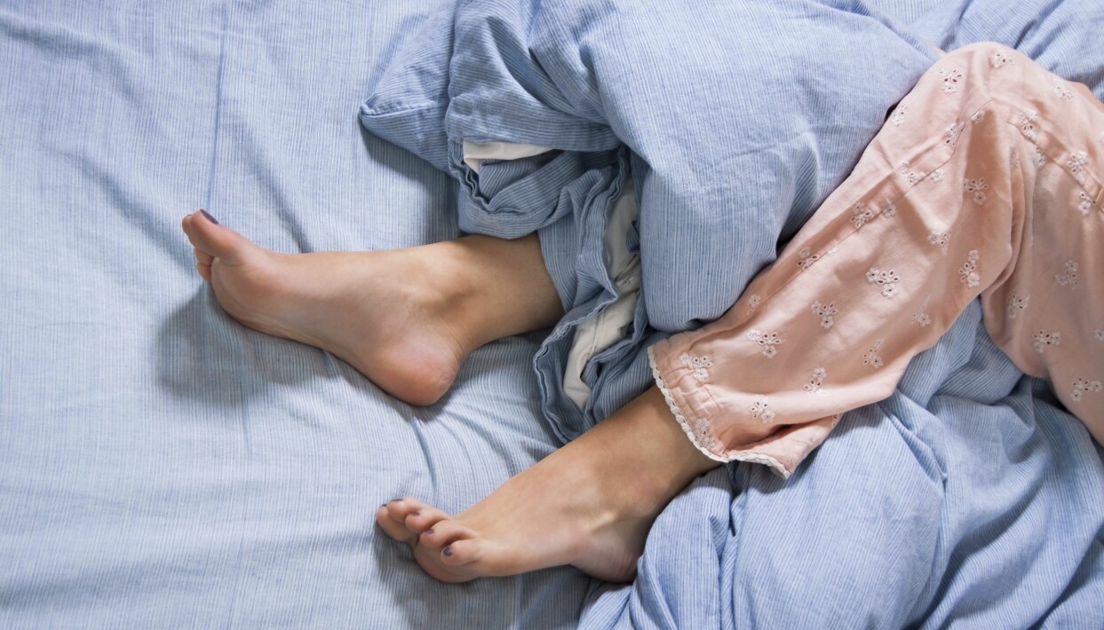 Se till att fötter och vader vilar fritt och inte ligger i kläm i lakanen. Foto: Shutterstock/TT Kvinnas ben inlindade i ett täcke.