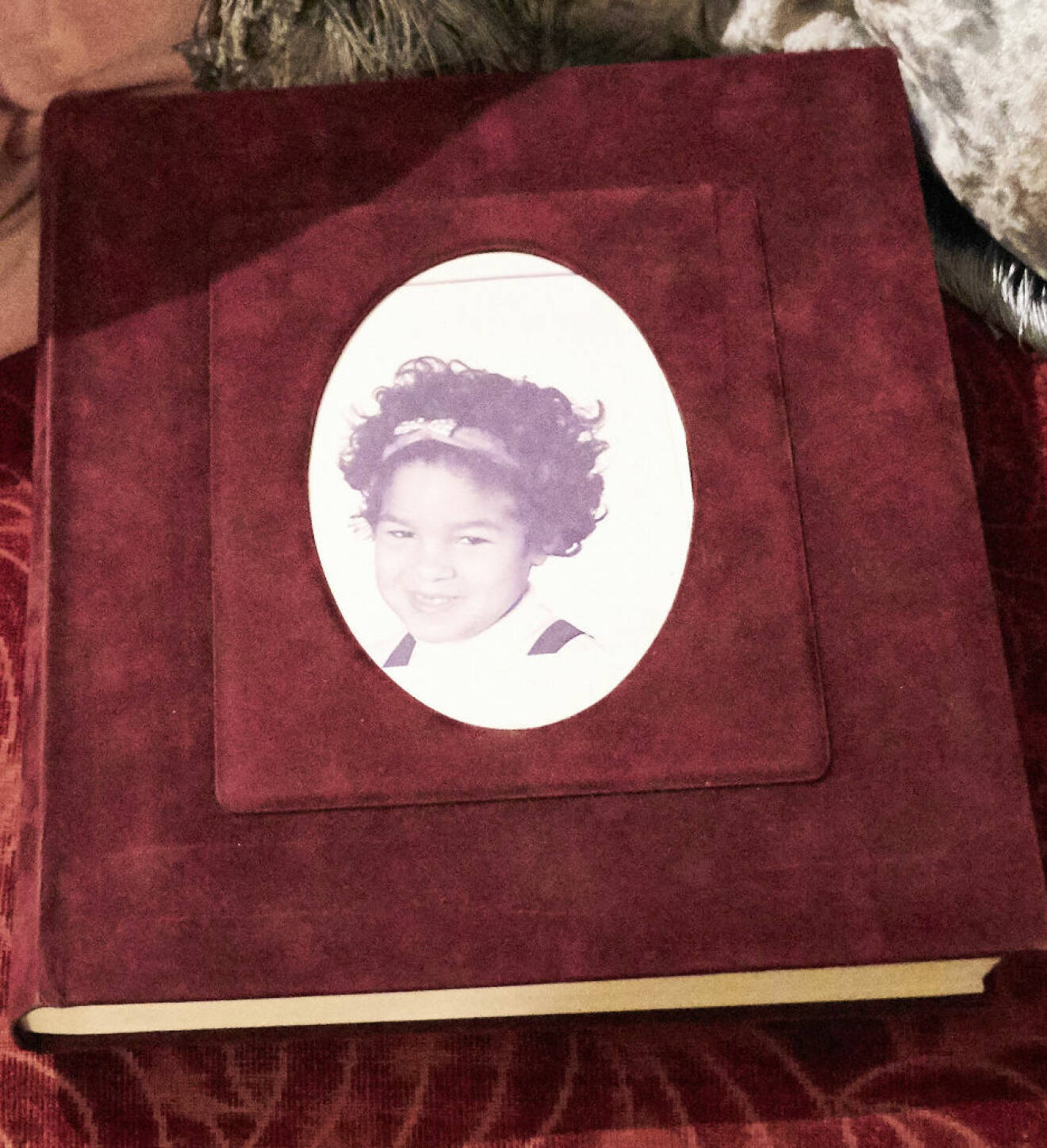 Fotoalbum i vinrött sammet och med Kirstines bild på framsidan.