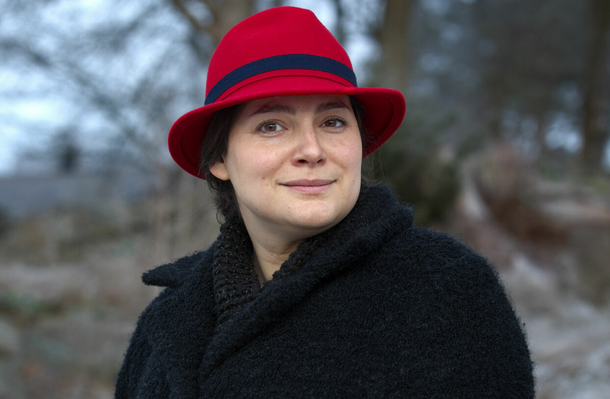 Nu har det gått snart tre år sedan Natalia hittade sin man död. Chocken har släppt men sorgen och saknaden finns kvar. Foto: Magnus Gotander. Natalia med ett litet leende i svart kappa och röd hatt.
