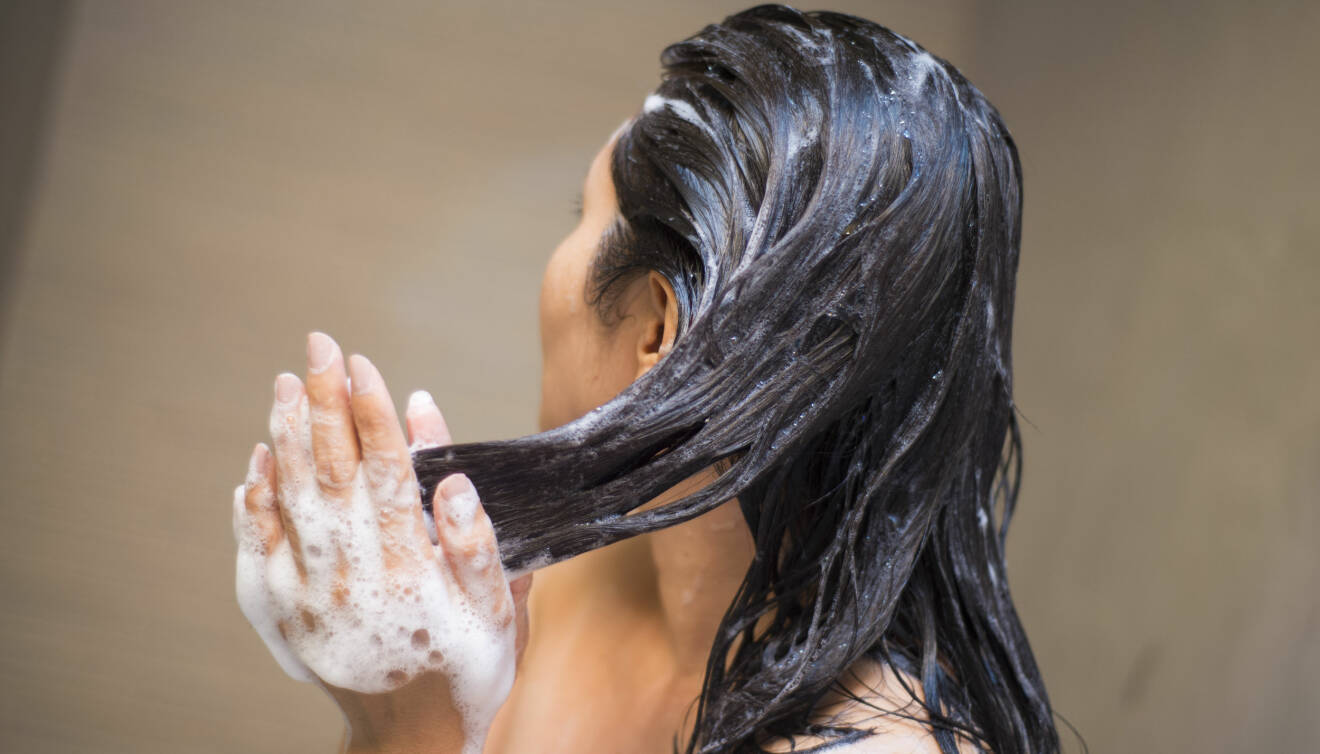 Kvinna tvättar håret med balsam.