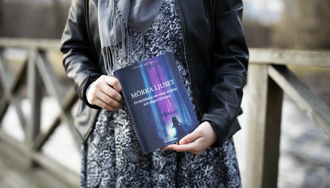 Zahra har skrivit en roman utifrån sina upplevelser. Den heter <i>Mörka ljuset</i>.<i> </i>Foto: Emma Norbäck Zahra visar upp sin roman Mörka ljuset.