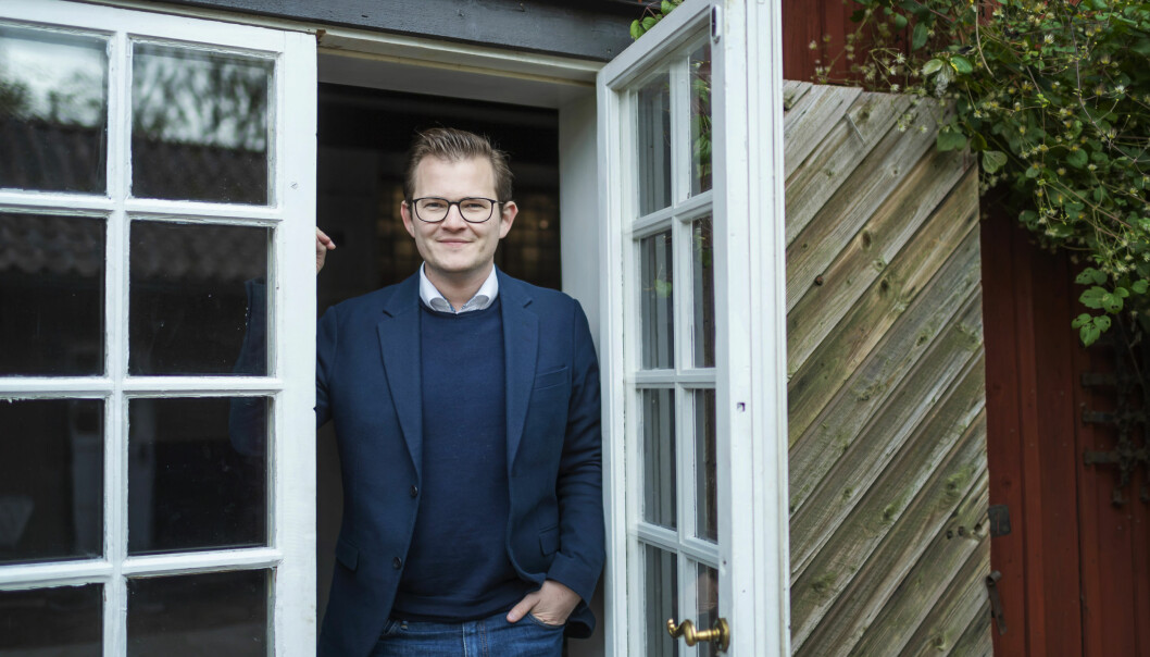 Jacob, 29. Foto: SVT/Stina Stjernkvist Jakob, 29 år och deltagare i Gift vid första ögonkastet 2020, står framför en glasdörr.