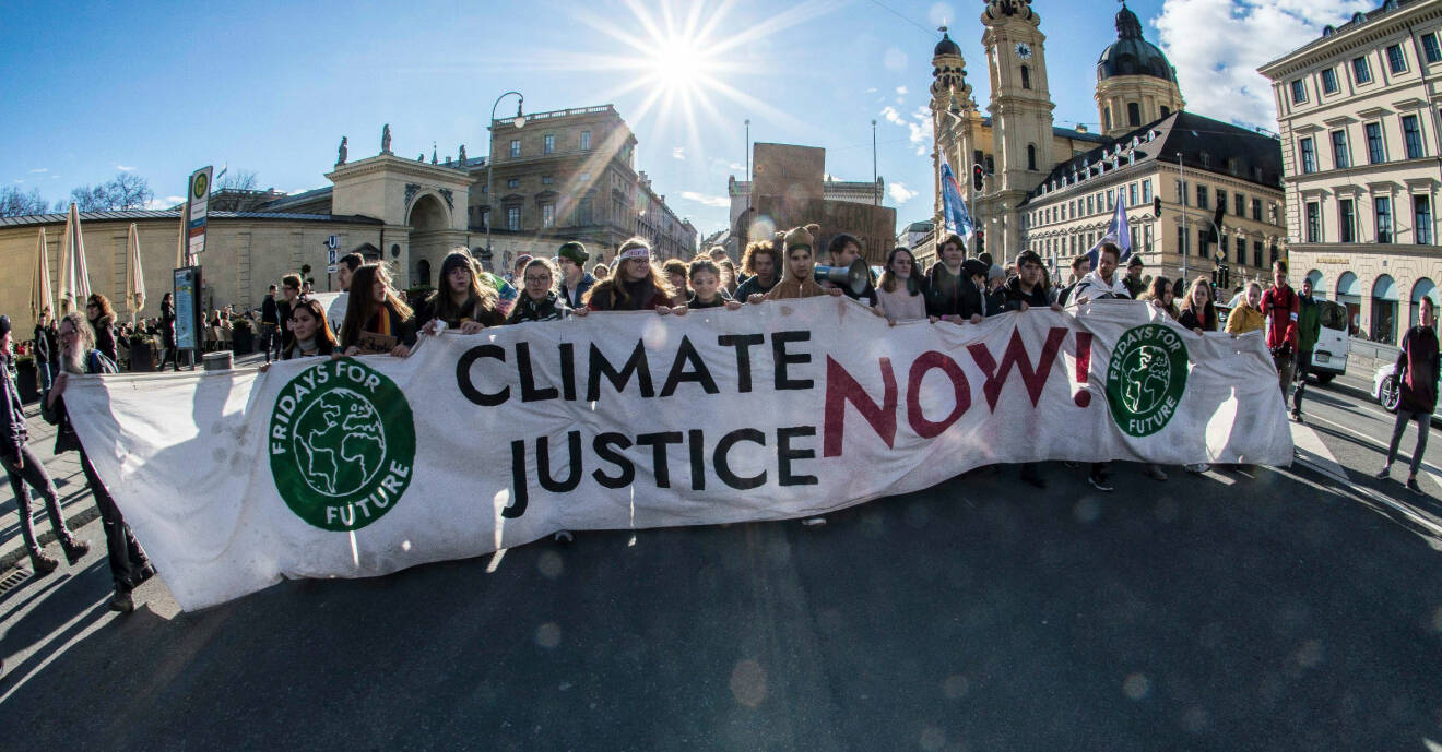 En grupp ungdomar strejkar för klimatet med en stor banderoll.