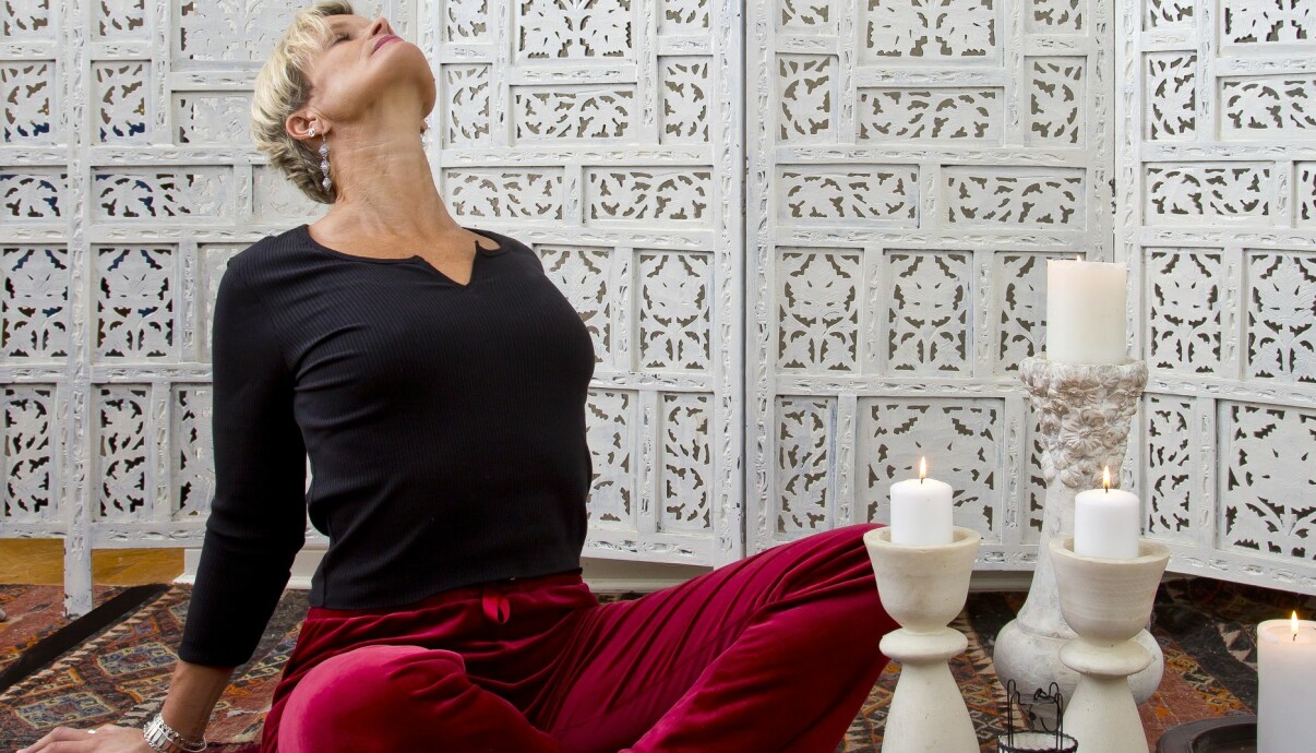 Kvinna gör yoga och stretchar axlar och bröst.