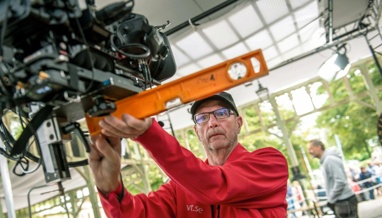 Ska det vara ordentligt, så ska det! Med vattenpass kontrollerar fotografen Tomas Nilsson att filmkameran har ett plant, exakt avpassat underlag. ”Det är för att kameran ska förbli i horisontalläge hur vi än väljer att vinkla den,” förklarar han. Foto: Erik Karlsson En kameraman justerar en kamera med vattenpass bakom kulisserna på Antikrundan.