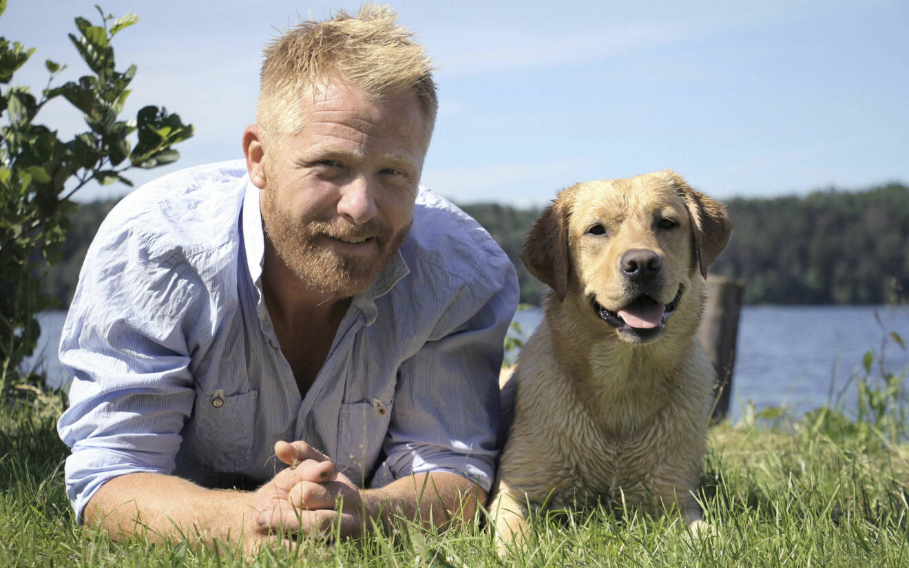 Hundcoachen Fredrik Steen med hunden Lilla Nymo i gröngräset.