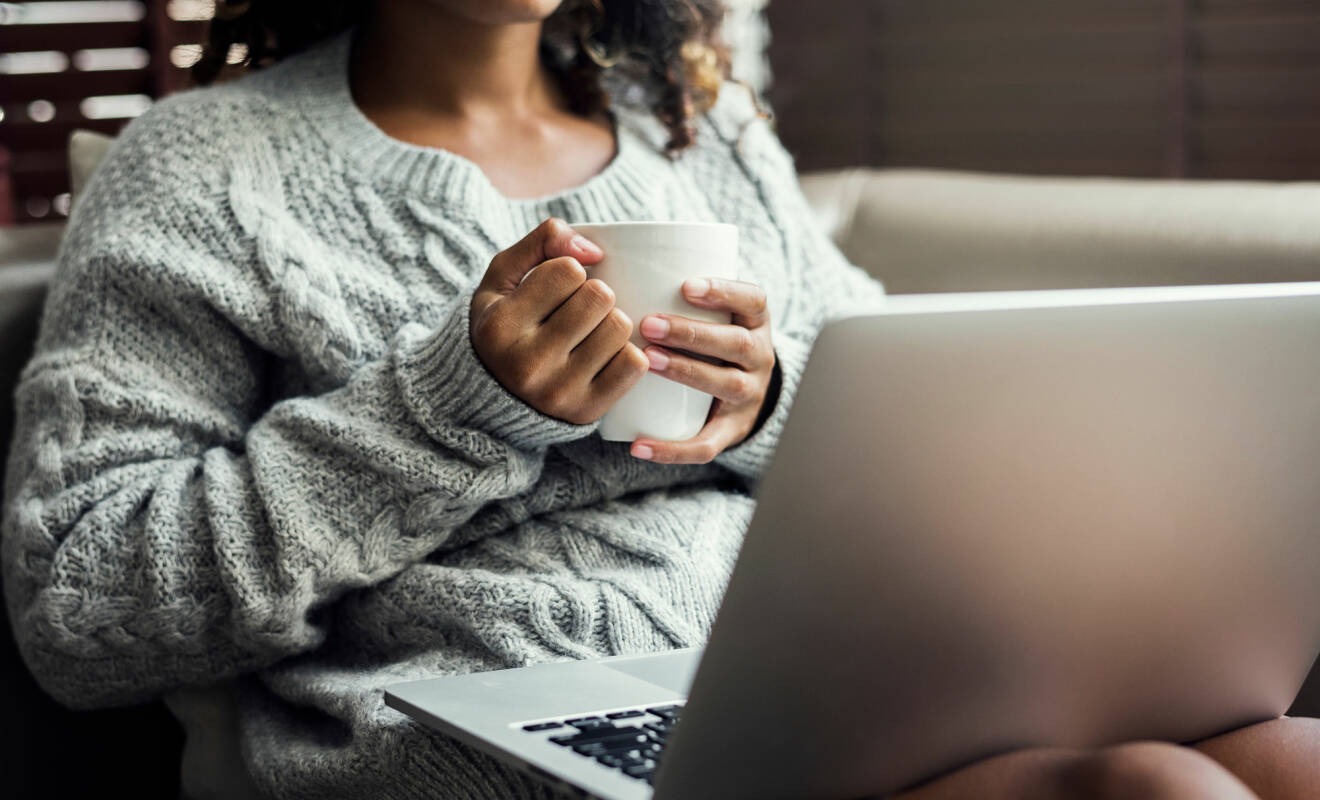 Kvinna sitter med en dator i knät.
