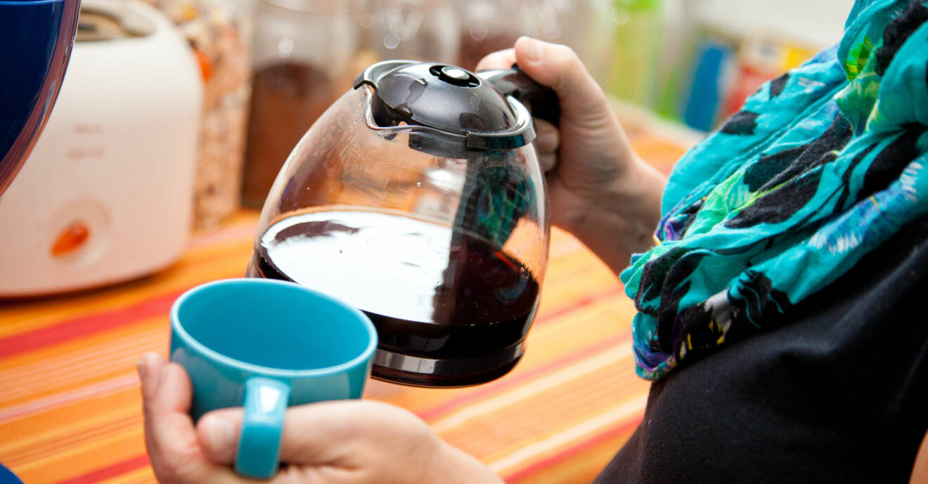 Kvinna häller upp kaffe i en kopp från en kaffebryggare.