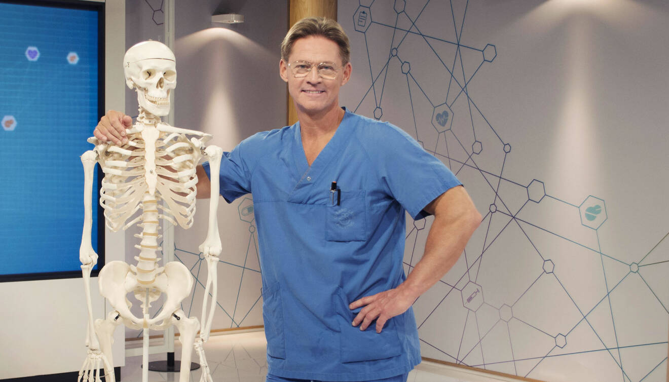 Soldoktorn Mikael Sandström poserar med ett skelett.
