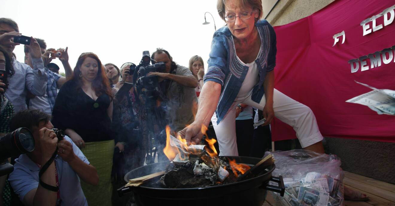Feministiskt initiativ-ledaren Gudrun Schyman bränner pengar i en grill.
