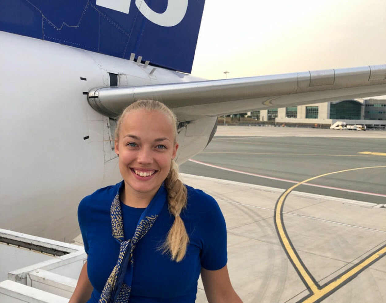 Mathilda Malm jobbar normalt som flygvärdinna. Foto: Privat Flygvärdinnan Mathilda Malm framför ett SAS-flygplan.