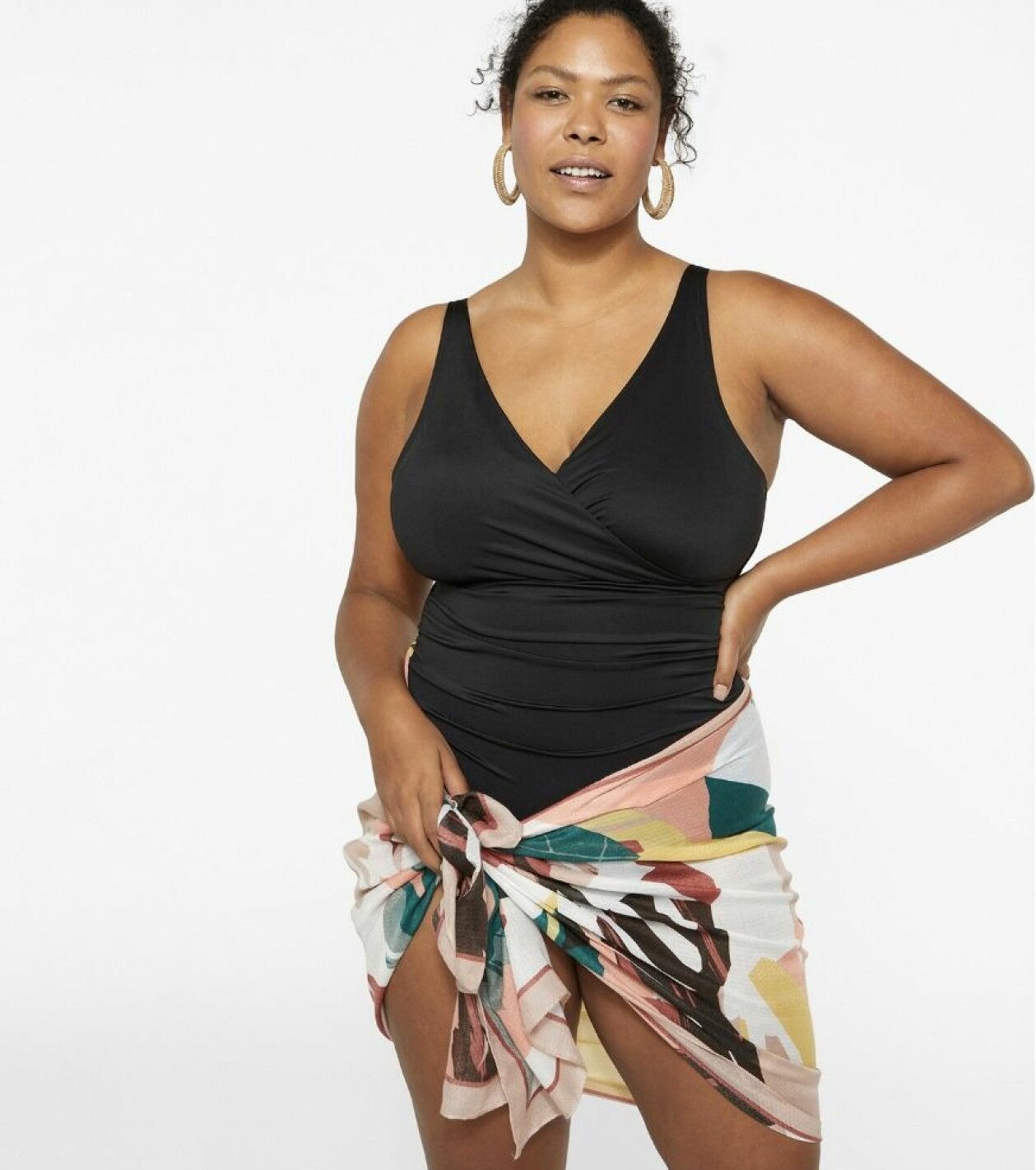 Svart baddräkt med draperade sidor samt mönstrad sarong, från KappAhl