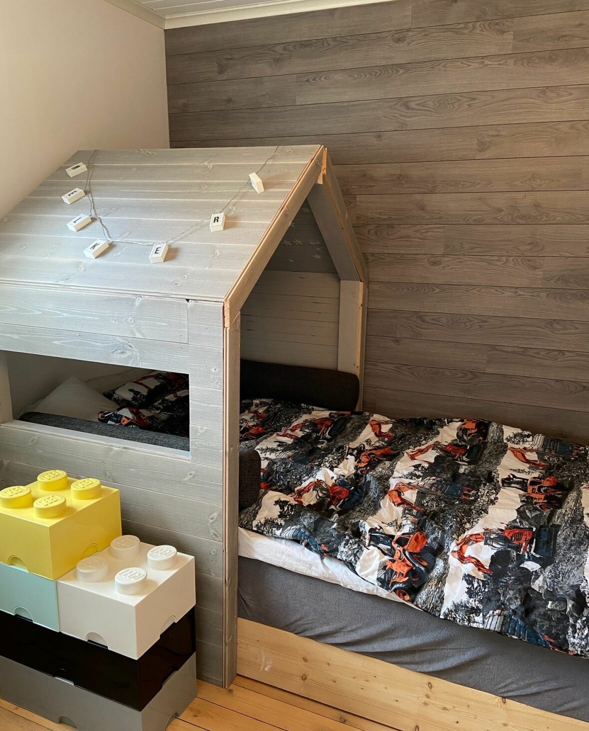 I sonens rum har Stina gjort ett litet hus, även det av överblivet golv. Stommen fick hon hjälp med av en snickare. Foto: Privat Ett barnsovrum med ett litet hus över sängen.
