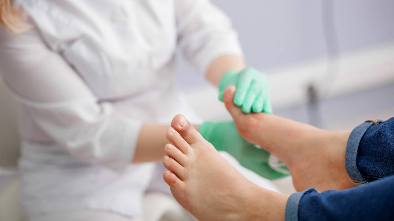 Läkare undersöker en persons fötter.