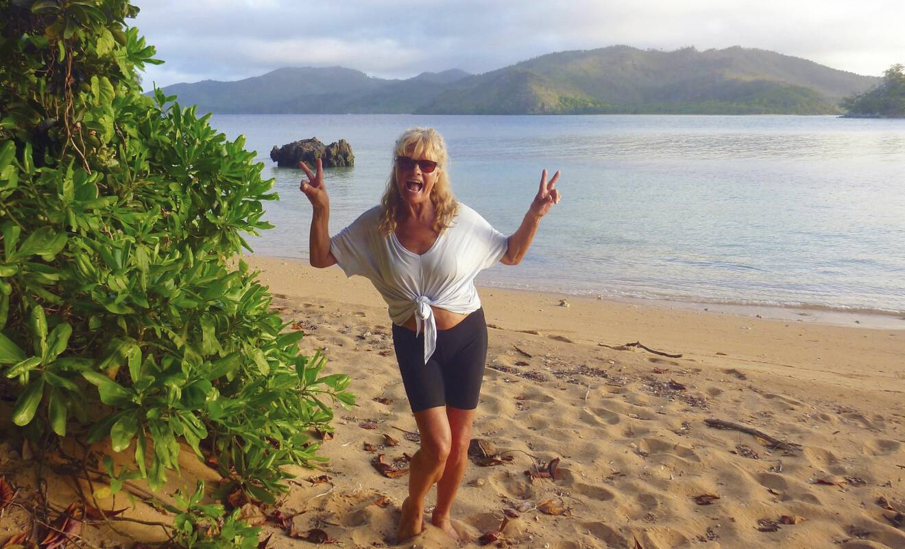 Pia, solbränd och glad, på en strand på Fiji.