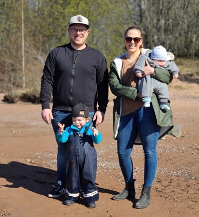 Julia Ljungqvist bor i Siljansnäs med sambon Andreas och sönerna Theo och Melker. En ung familj står utomhus i solen och ler in i kameran.