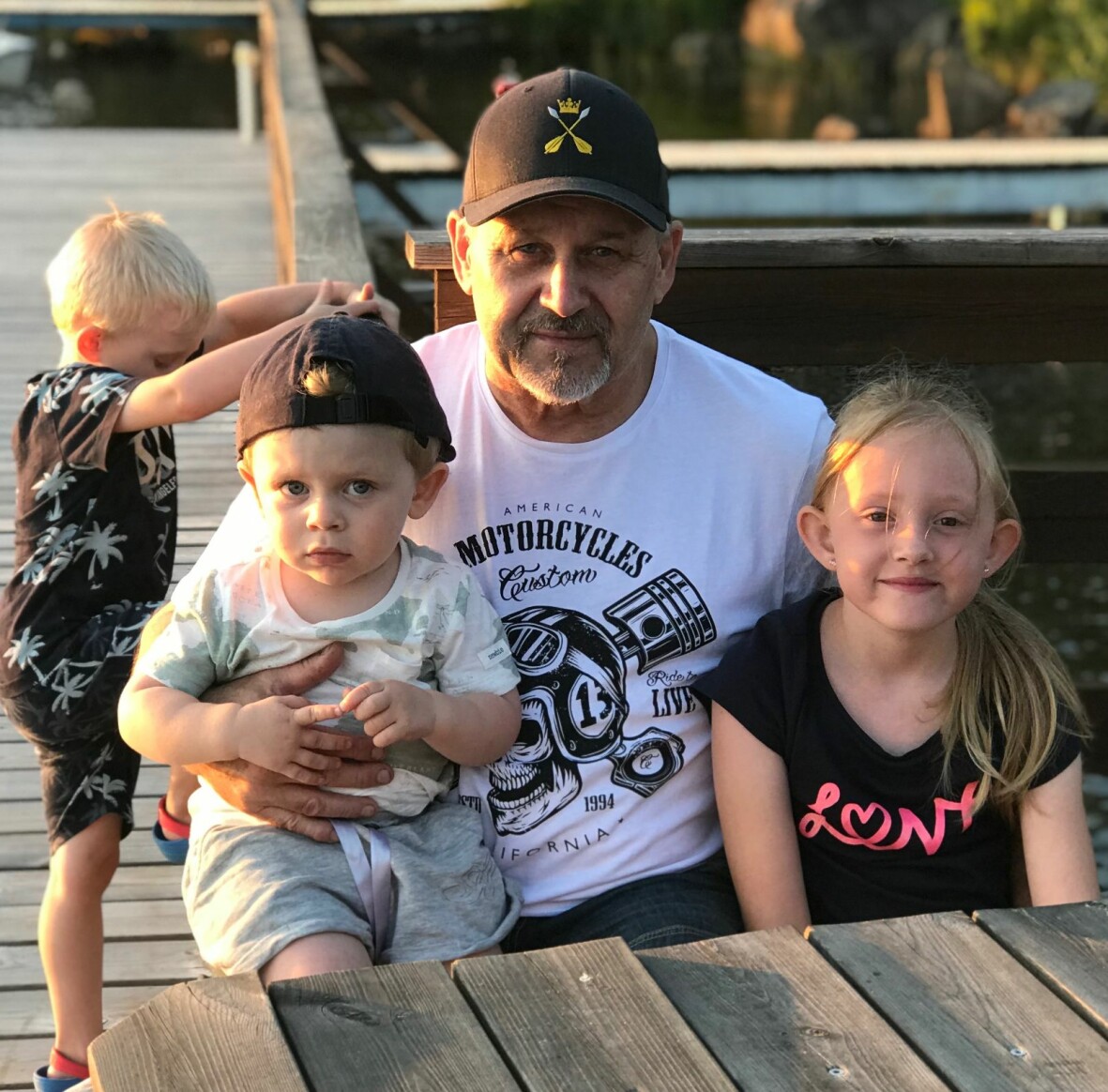 Lars är familjens busfarbror. Foto: Privat En äldre man sitter med två barn i knät.