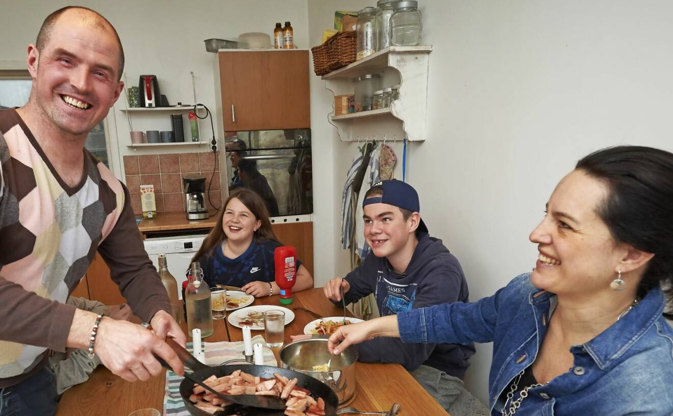 Familjen samlade vid ett middagsbord i köket, Stefan bjuder falukorv.