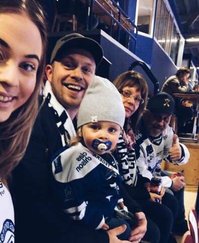 Snart kan nog Theo gå på hockey med mormor och morfar som vanligt igen! Foto: Privat En glad familj sitter på en läktare och ser på hockey.