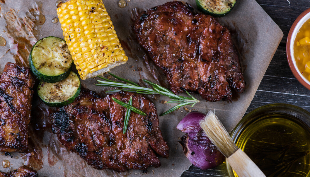 Fläskkött lägger flest svenskar helst på grillen. Foto: Shutterstock/TT Grillad majskolv, squash och fläskkotletter som ligger på ett bord.