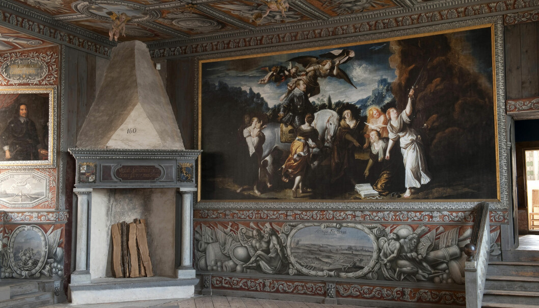 Kungssalen i Läckö Slott. Foto: Håkan E Bengtsson Ett rum i slottet där pampiga målningar täcker väggar och tak. I hörnet står en massiv öppen spis.