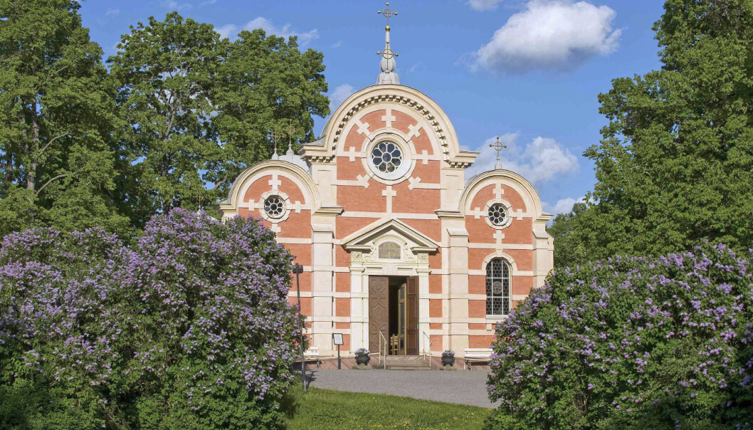 Slottskapellet Ulrikdals slott. Foto: Håkan Lind/ Kungliga Hovstaterna En bild på Ulrikdals Slottskapell i solljus, omgiven av lila syrenbuskar.