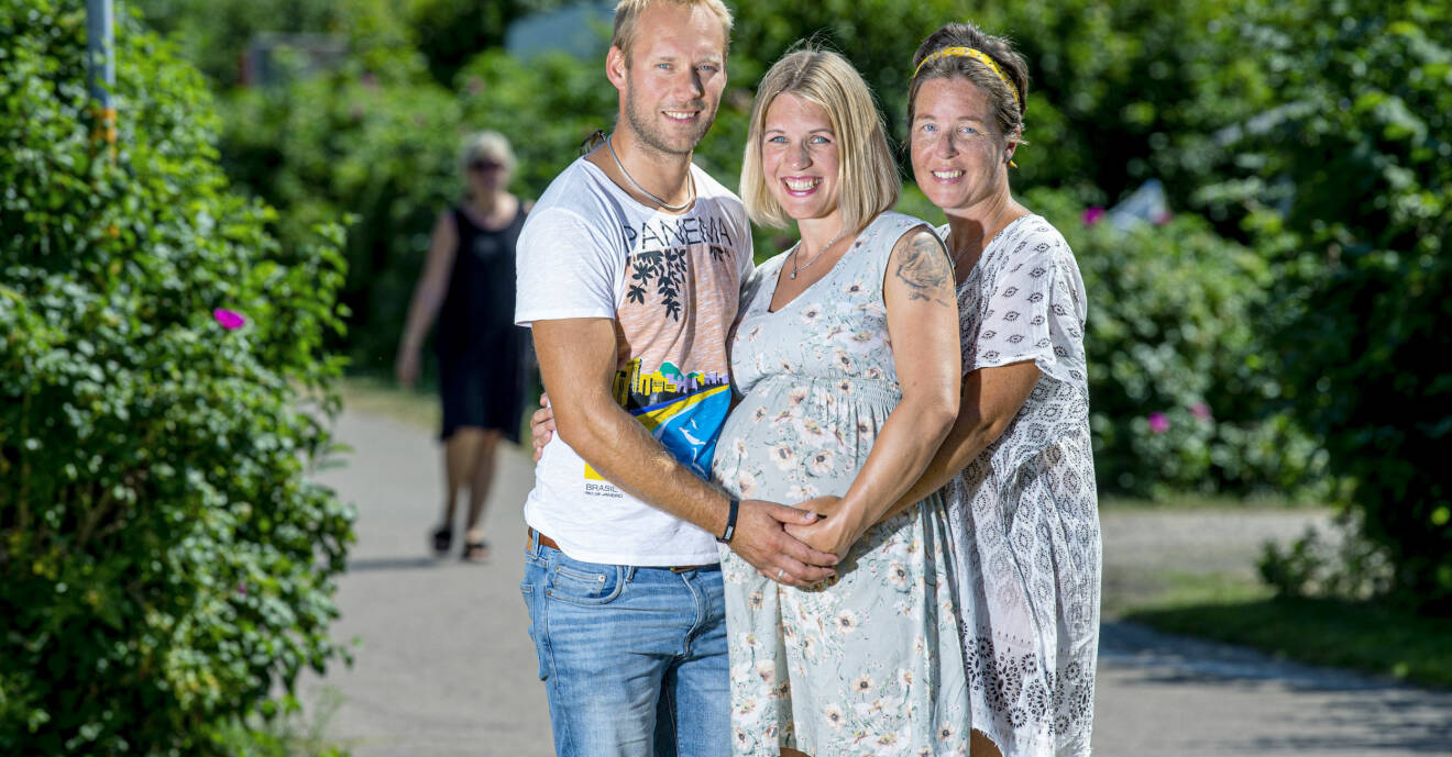 Adam och Sandra står på varsin sida om Linnea och alla ler och håller händerna på Linneas runda gravidmage.