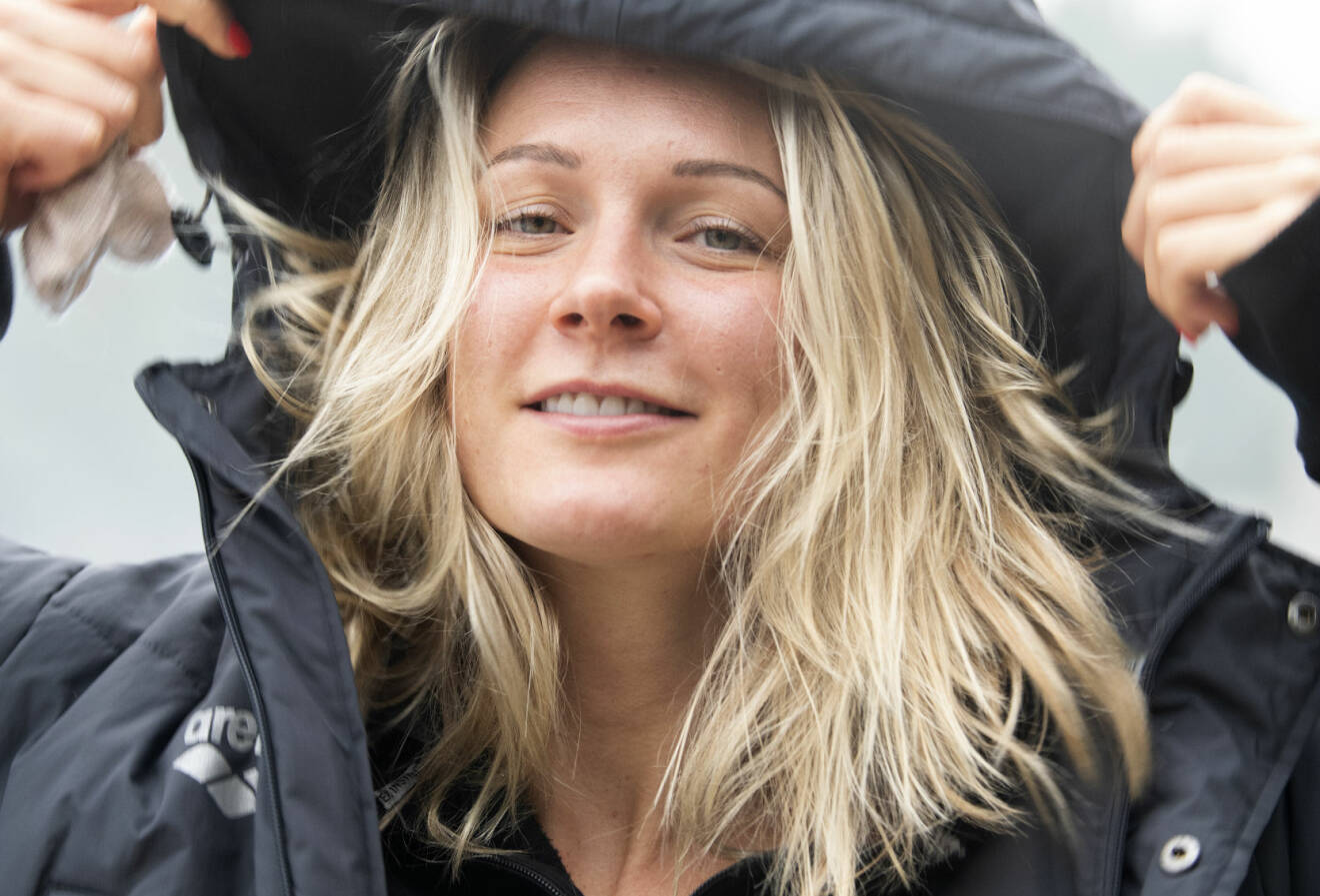 Sofia Sjöström drar upp luvan på sin täckjacka och tittar in i kameran.