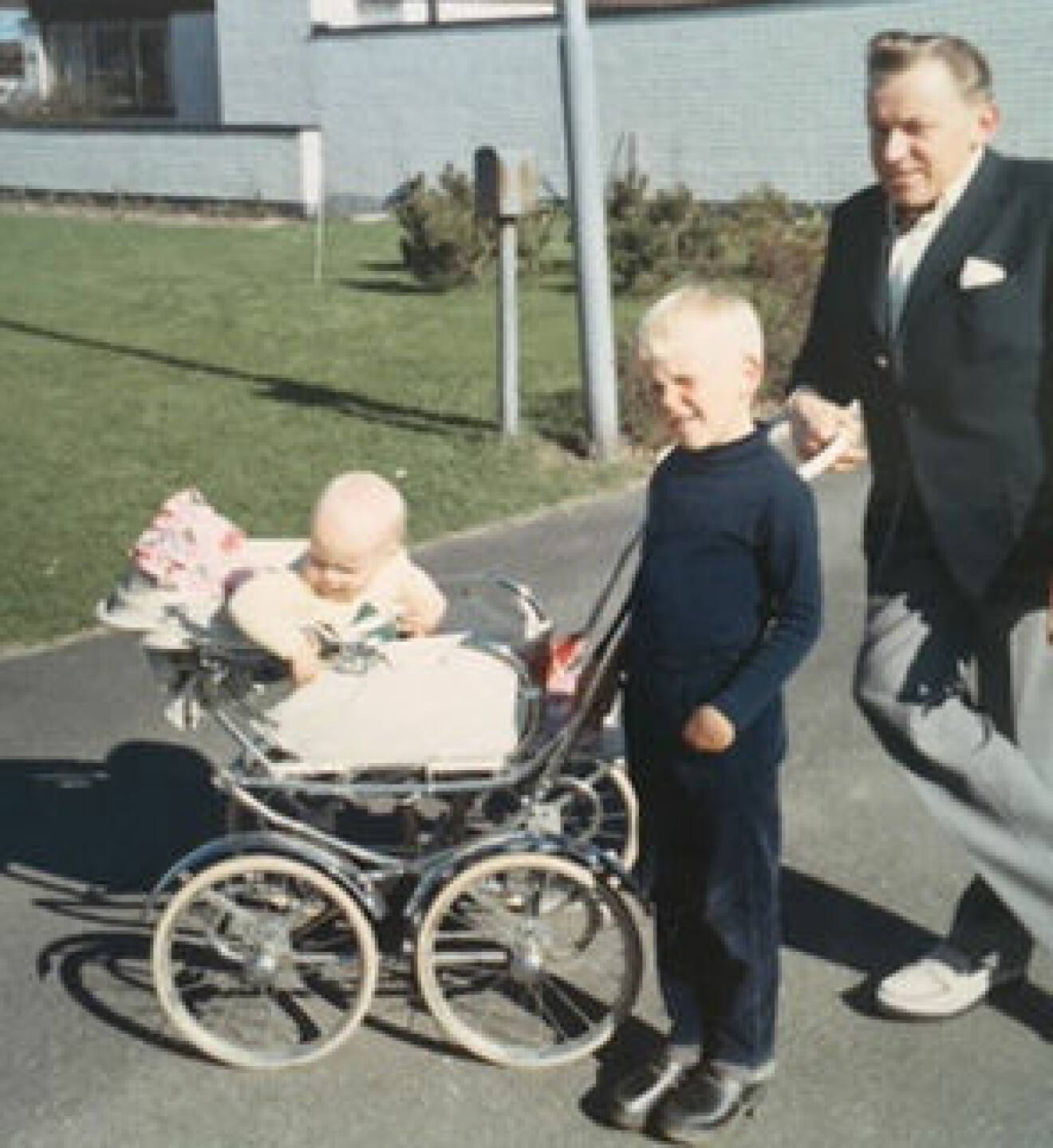 En liten Janne med pappa på barnvagnspromenad.