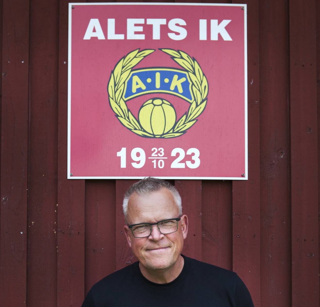 Janne porträtt under röd Alet-skylt.