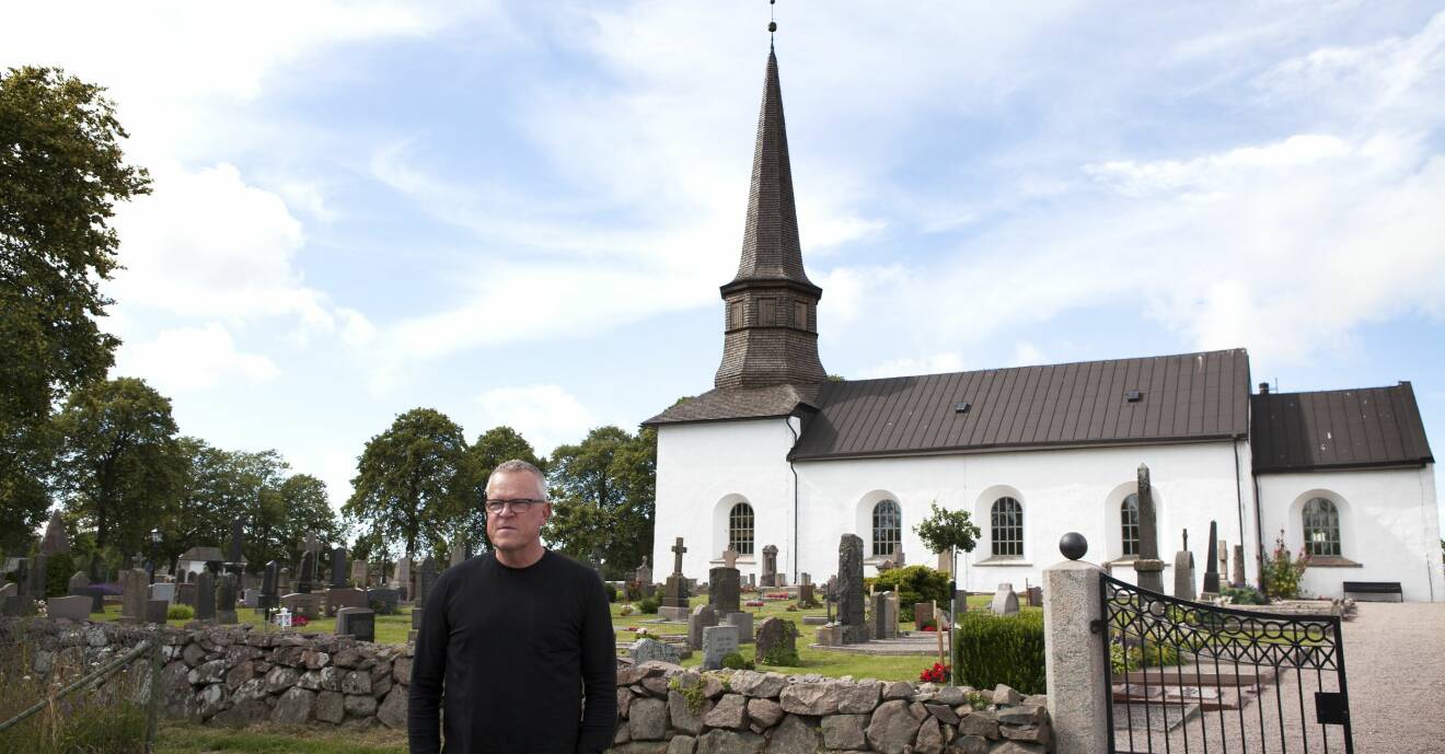 Janne framför vitkalkad kyrka.