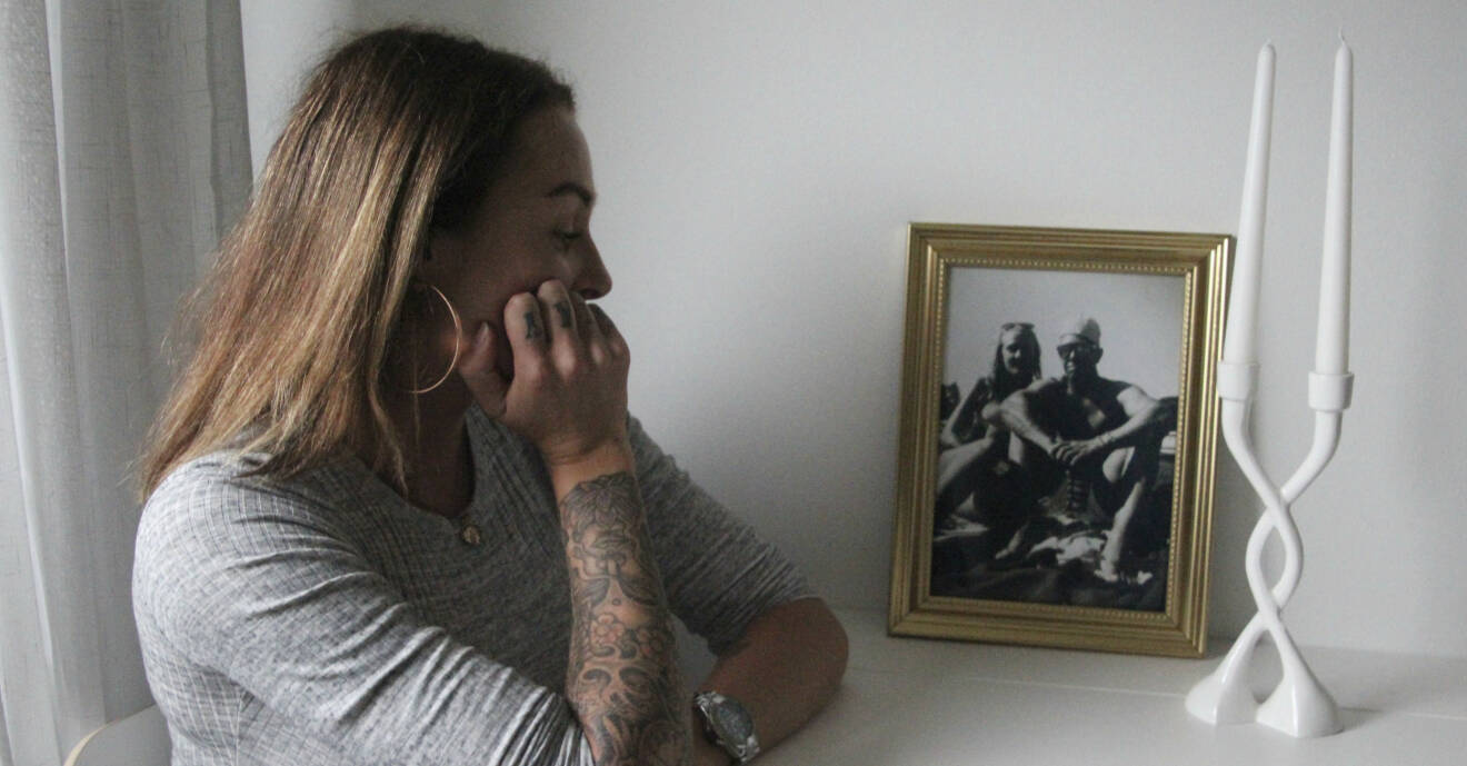Therese sitter vid köksbordet och ser nostalgiskt på ett porträtt av henne och hennes tidigare partner Jens.