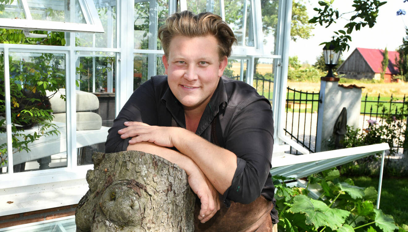 Karl Fredrik på Österlen står i sin trädgård på gården Eklaholm och ler mot kameran.