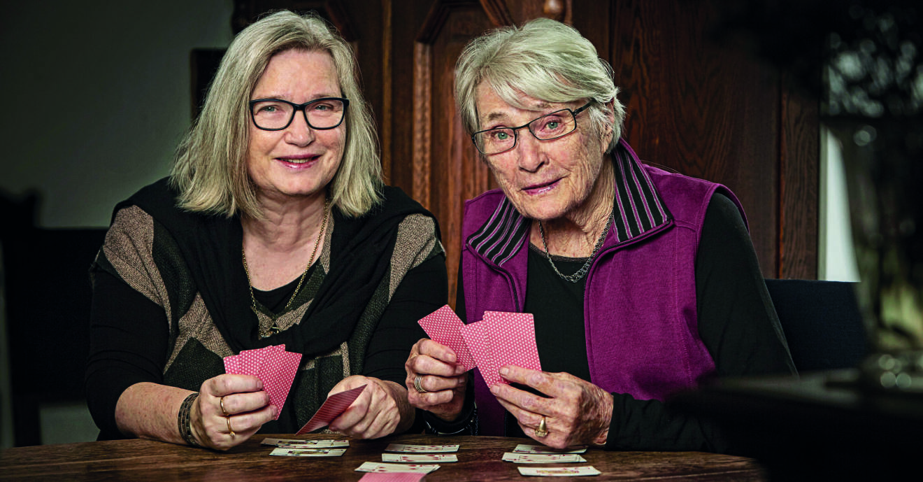 Två kvinnor, mor och dotter, som spelar kort.