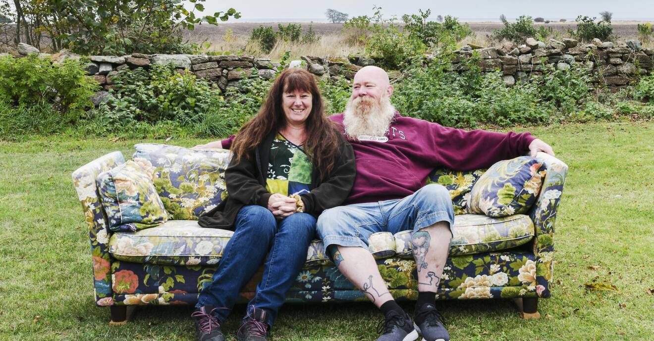 Par som sitter i en soffa ute på en gräsmatta.