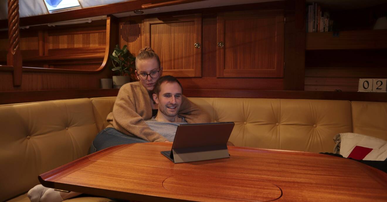 Ett par sitter i sin båt med en dator.